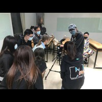 學生向嚴孟修導演學習攝影拍攝技巧。
